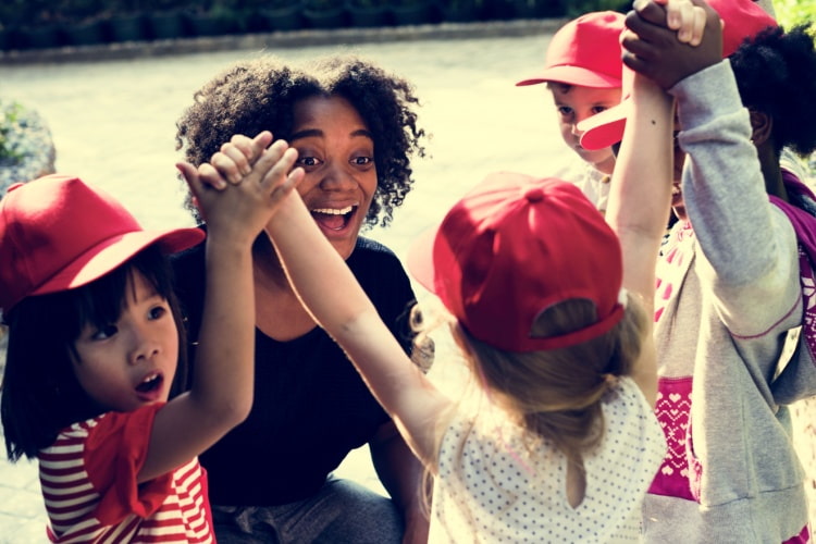 a teacher laughs with her students outside on a field trip