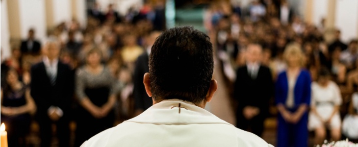 a priest speaks to his congregation from the pulpit
