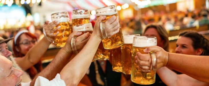 a group of friends cheers with large beer steins